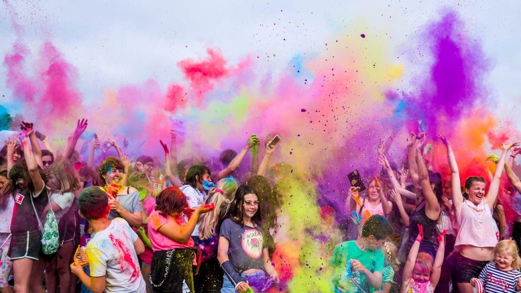 pexels-photo-1684187 A joyful crowd covered in vivid colors celebrates a festival outdoors with flying powder.
